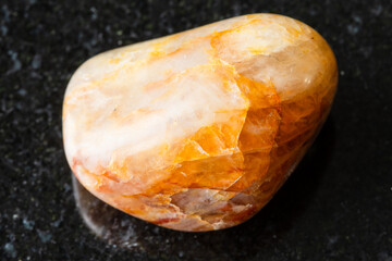 sample of polished orange quartz rock on black