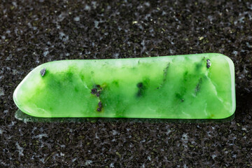 sample of polished green nephrite mineral on black