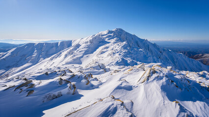 Majestic snow covered mountain peak under a clear blue sky