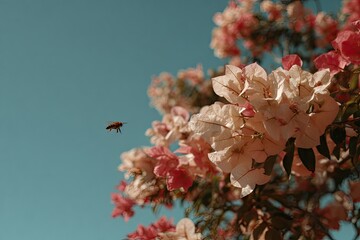 A bee flies amongst delicate, pastel-colored blossoms.