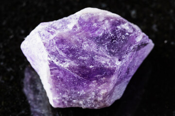 sample of rough amethyst mineral on black granite