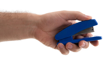 Hand holding a blue stapler to fasten papers together during a work session at a desk