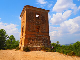 Requena,19th century telegraph tower in Mediterranean countryside, historic communication building under bright blue sky 
