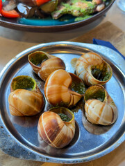 Snails with pesto sauce in a French restaurant. French national cuisine