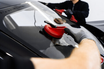 Windshield Installation Using Suction Lifters. Two technicians install windshield using suction...