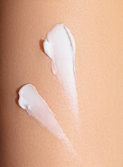 swatch of white cream on skin background, macro texture of the skin on which the cream is applied