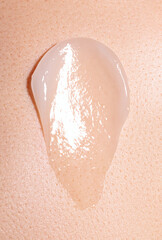 Fototapeta premium swatch of white cream on skin background, macro texture of the skin on which the cream is applied