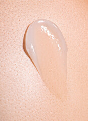 swatch of white cream on skin background, macro texture of the skin on which the cream is applied