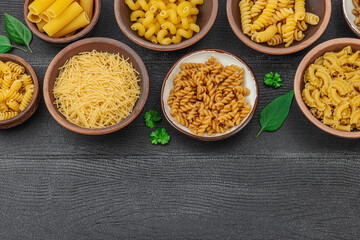Pasta. Various kinds of uncooked pasta and noodles over wooden background. Traditional Italian
