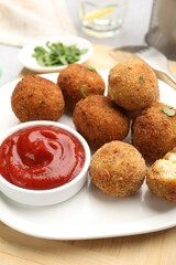 Delicious fried croquette balls with parsley and ketchup on table, closeup