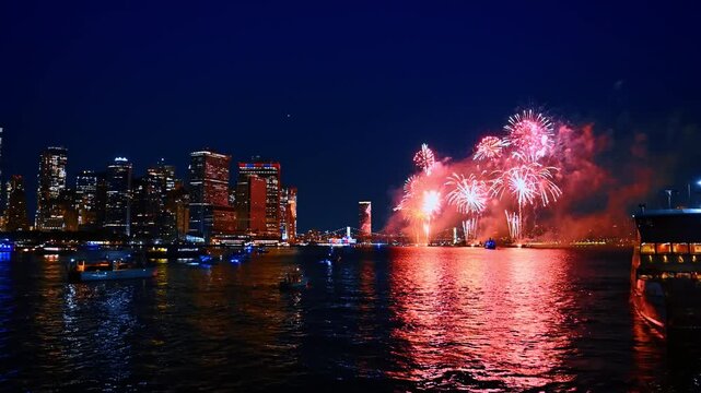 Gorgeous firework show among the night skyline of modern metropolis. Beautiful celebration in New York, USA. View from the waterscape.