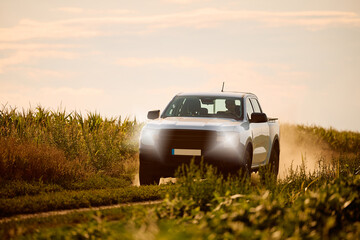 Farmer driving his pick-up truck through field. © Drazen