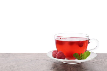 Tasty raspberry tea in glass cup, berries and mint on wooden table against white background