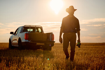 Full length of farmer working in field at sunset.