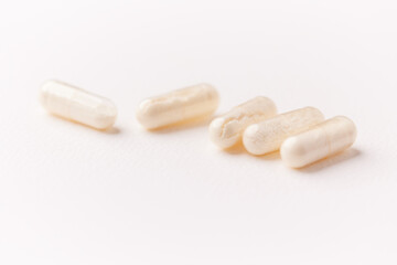 Coenzyme Q10 capsules. Antioxidants. Concept for a healthy dietary supplementation. Bright paper background. Soft focus. Close up. Copy space.	