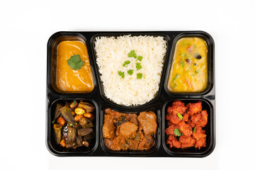 Indian Thali served with rice, okra, mushrooms and spices Menu Item on white background,, top down view