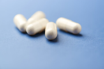 Creatine tablets on paper background. Soft focus. Close up. Copy space.	