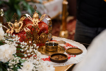 Orthodox Wedding Ceremony Detail: Golden Crosses, Red Velvet Cloth, and Symbolic Rings on Altar. Spiritual Ritual, Religion, White Flowers