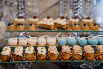 Elegant Wedding Dessert Table with Pastel Mini Cakes and Cream Puffs Displayed on Tiered Stands, Luxurious Celebration Concept