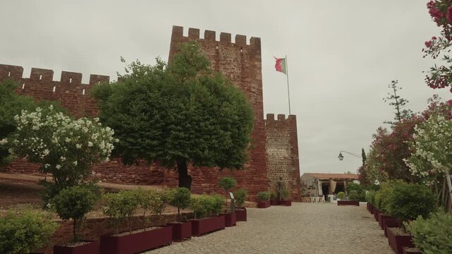 Entrance pathway to Silves Castle with Portuguese flag, Algarve, Portugal