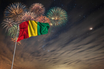Waving National flag of Guinea and holiday fireworks