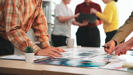 A diverse group of professionals actively collaborating in a stylish office environment, analyzing data reports and business strategies during a productive meeting. SACTR