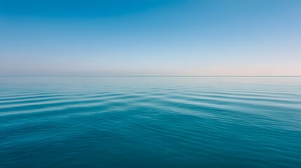 Fototapeta premium Calm water surface reflecting a clear sky.