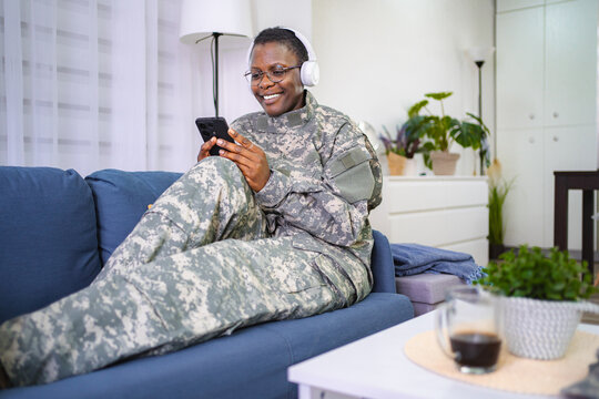 Relaxed Soldier Enjoying Music on a Couch - Powered by Adobe