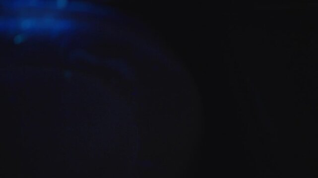 Ultraviolet light revealing white mineral buildup on bathroom sink surface in dark washroom, highlighting cleaning importance for maintaining sanitary conditions. Concept of hygiene and cleanliness.