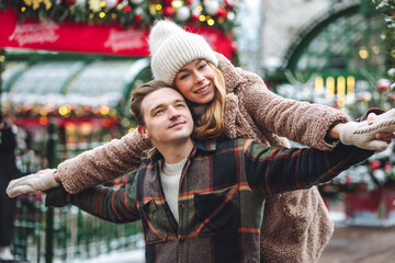 Beautiful young loving couple embracing, kissing, enjoying winter vacation, cold snowy day on a...