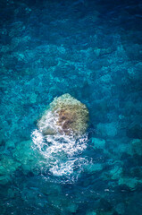 Lonely Rock Breaking a Wave in Atlantic Waters