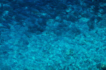 Blue Transparent Water Surface with Underwater Rocks
