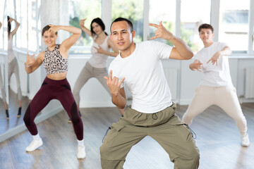 Naklejka premium Team of dancers performing contemporary dance in ball room