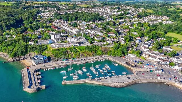 A receding aerial view across the harbour in the early morning in Saundersfoot, South Wales in summertime
