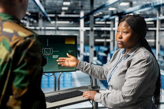 Team of military experts doing brainstorming, looking at encrypted satellite intel in data center. Teamworking army server farm colleagues extracting enemy movement data using satellite technology