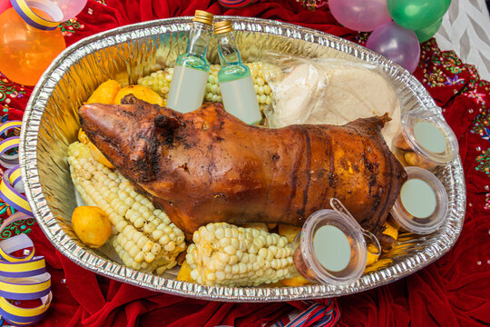 Traditional dishes from the highlands of Ecuador: cuy asado (roasted guinea pig), mote (boiled ripe white corn), potatoes, cheese, drinks and sauce