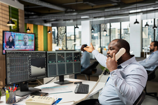 Trader desperately calling clients after stock market crash caused by Black Swan event causes them to lose money. Worried stockbroker in telephone call with customers to share recession news