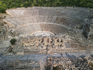 Massive seating of the great theatre curves around the orchestra, weathered stones reveal age and scale, stage masonry adds detail, ancient Ephesus Turkey invites archaeology lovers and travel