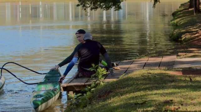Two People Preparing Kayak by the Lake
 - Powered by Adobe