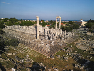 Aerial view shows the massive podium of the Temple of Apollo at Didyma, two standing columns rise above drums and steps, the Aegean coast of Turkey keeps the sacred sanctuary in memory