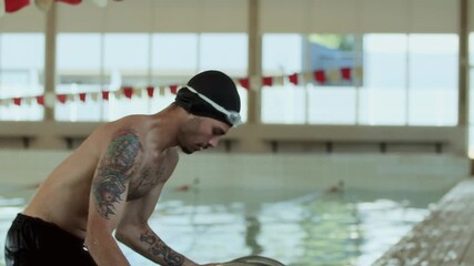 Male swimmer leaving pool after training session