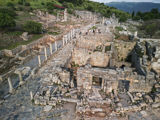 Aerial view follows a marble avenue through upper Ephesus, foundations and columns trace shops and houses, the scene opens to valley and hills, a timeless page of ancient Turkey's history