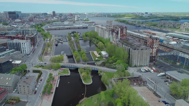 Aerial view of Montreal, Canada, showcasing the industrial port area with grain elevators, canals, and the St. Lawrence River, highlighting urban landscape. Lachine Canal National Historic Site.