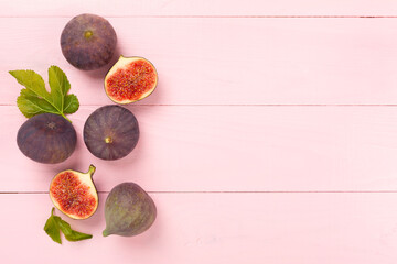 Fresh tasty fig fruits on wooden background, top view