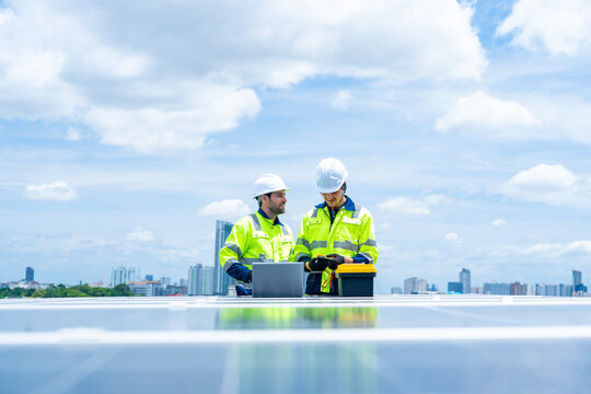 Solar cell, electricity alternative renewable clean energy for environmental conservation, sustainability technology. Male engineer maintaining solar panel system on construction site building rooftop