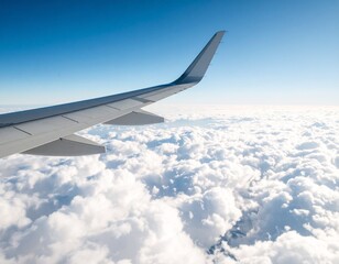 Fototapeta premium Above the Clouds: An airplane wing soars through a bright blue sky, offering a stunning view of a vast sea of fluffy clouds below, evoking the sense of adventure and freedom.
