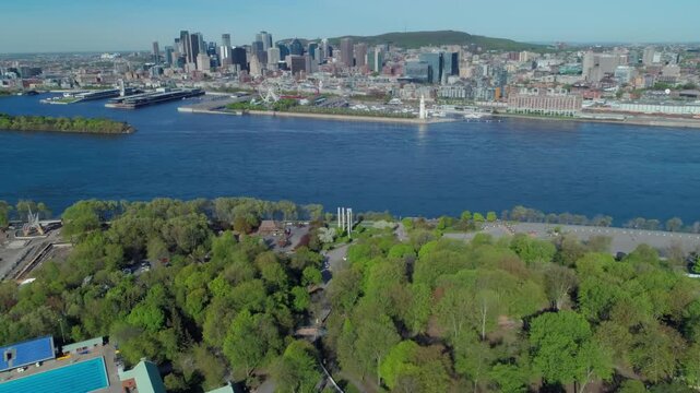 Aerial view of Montreal, Canada, featuring Parc Jean-Drapeau, the Saint Lawrence River, and the Montreal skyline. The park offers recreation and green space.