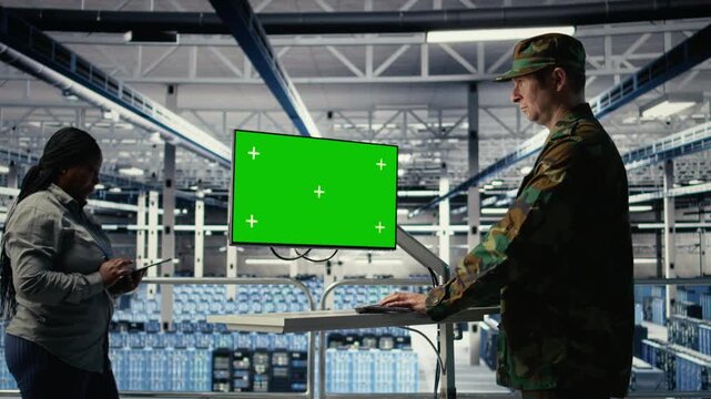 Army programmer in server hub uses AI application on green screen mockup PC to review reconnaissance information. Military data center worker uses AI on chroma key computer to plan mission, camera A