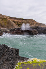 Cliffs with water spouting up from ocean