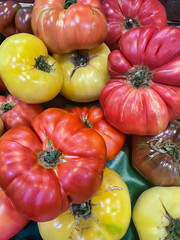 Different colors of heirloom tomatoes on display at a local market.